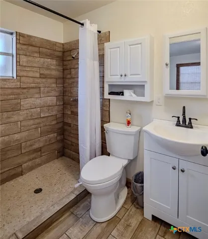 a bathroom with a sink a toilet and shower