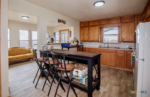 a kitchen with a table chairs sink and cabinets