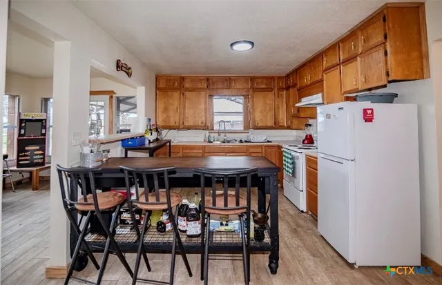 a kitchen with a table chairs and a refrigerator