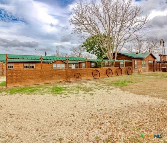 a view of swimming pool of water with lawn chairs and large trees