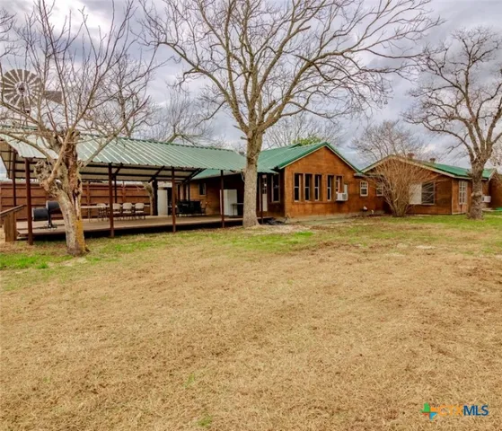a front view of a house with a yard and large trees