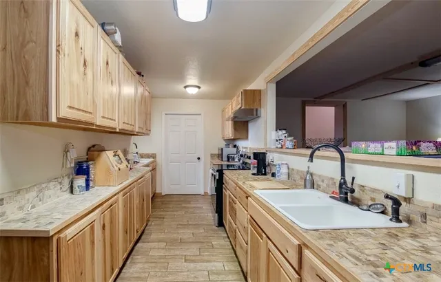a kitchen with stainless steel appliances granite countertop a sink stove and cabinets