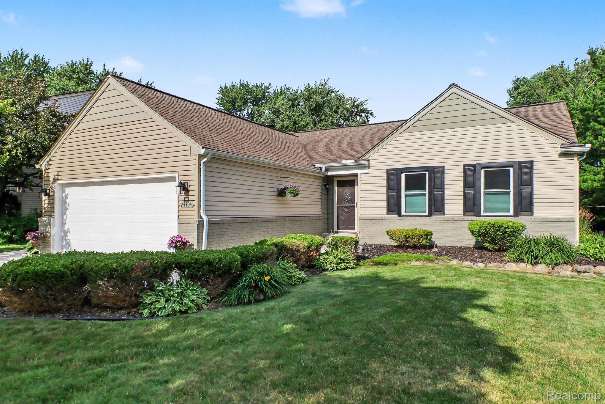 24404 Jamestowne Road Novi, MI 48375 - Photo 3 of 26 Charming ranch-style home featuring a two-car attached garage, cream-colored vinyl siding, and a gabled roofline