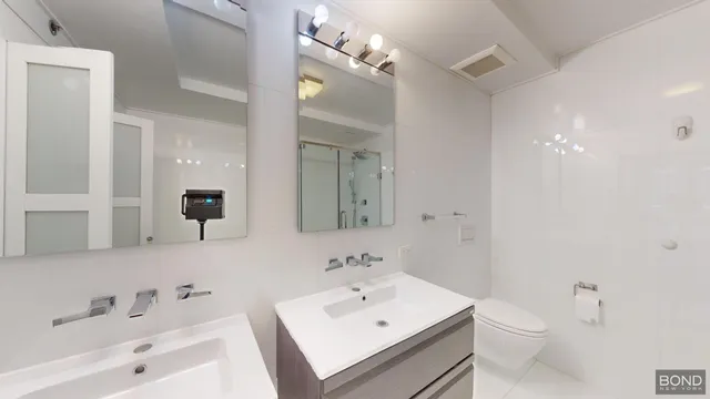 a bathroom with a sink a toilet and a mirror