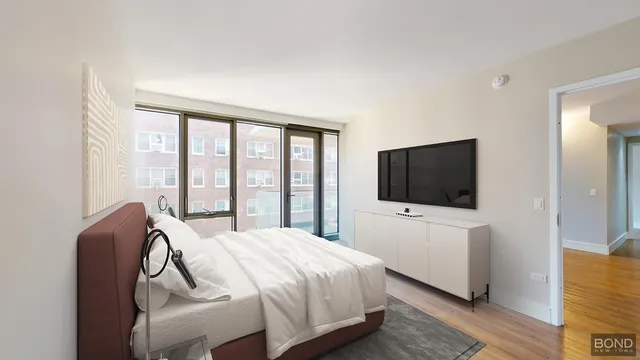 a bedroom with a bed and a flat screen tv