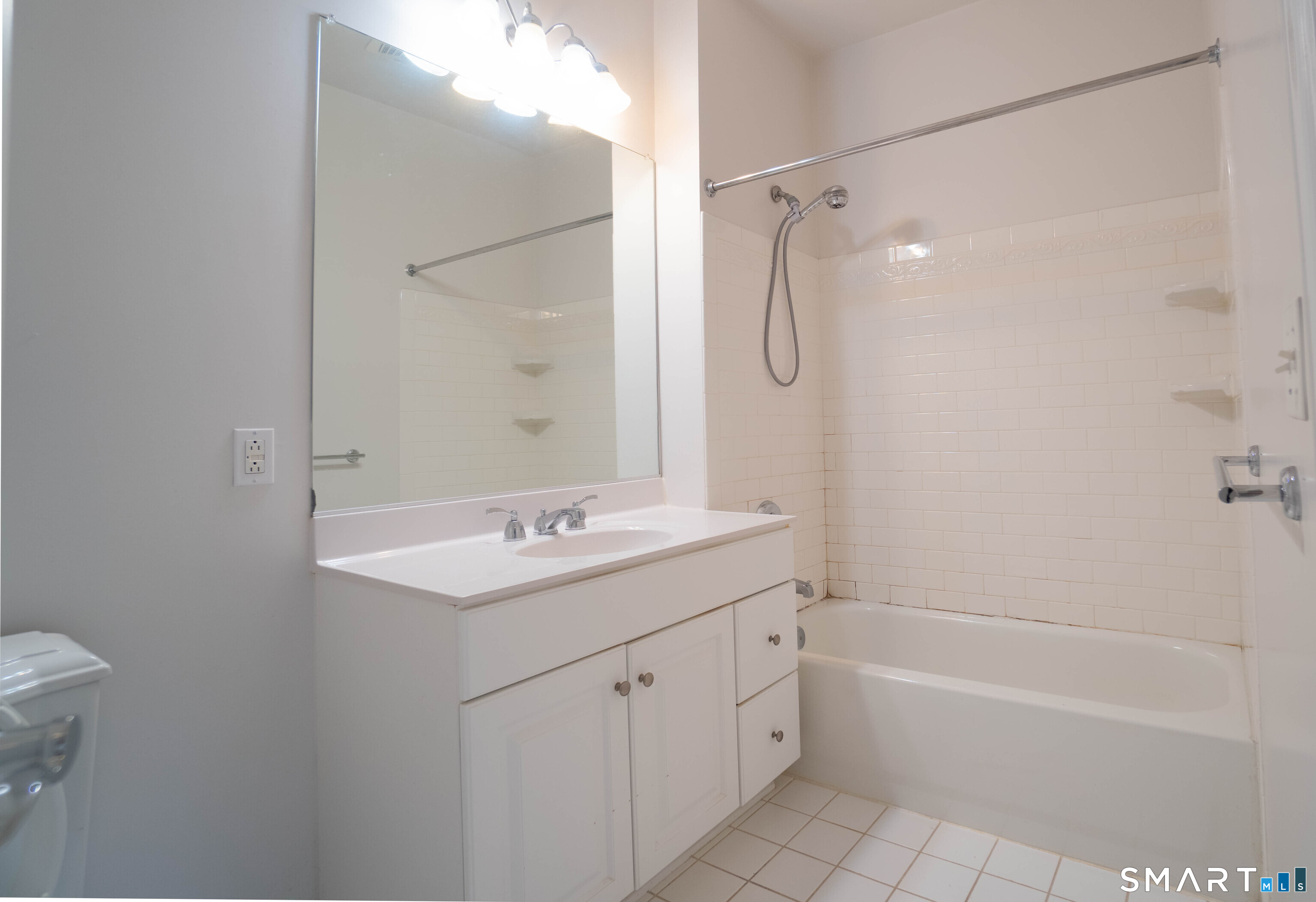 25 Adams Avenue, Unit 112 Stamford, CT 06902 - Photo 15 of 17 a bathroom with a tub sink toilet and a mirror