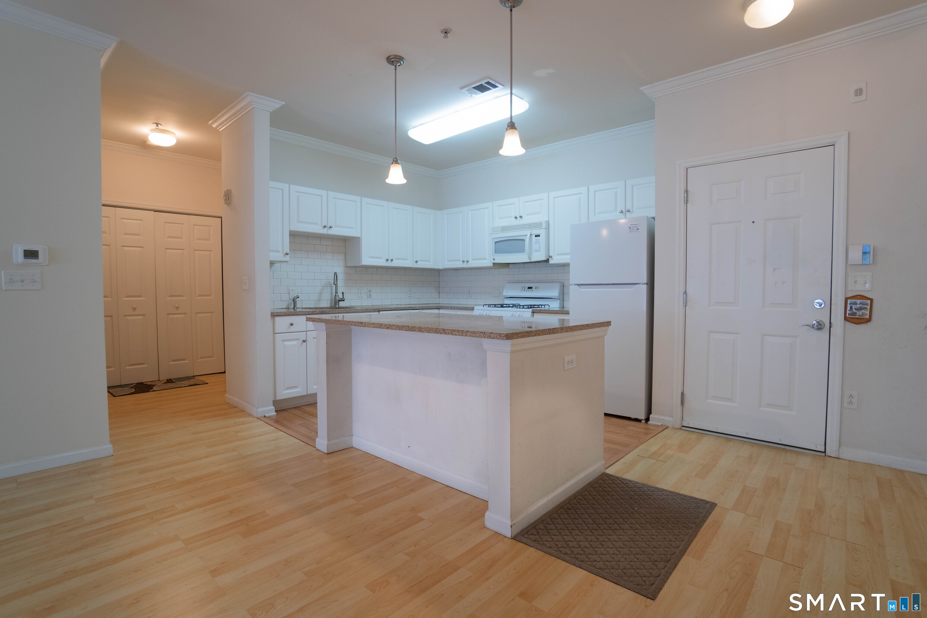 25 Adams Avenue, Unit 112 Stamford, CT 06902 - Photo 4 of 17 a kitchen with kitchen island a sink stainless steel appliances and cabinets