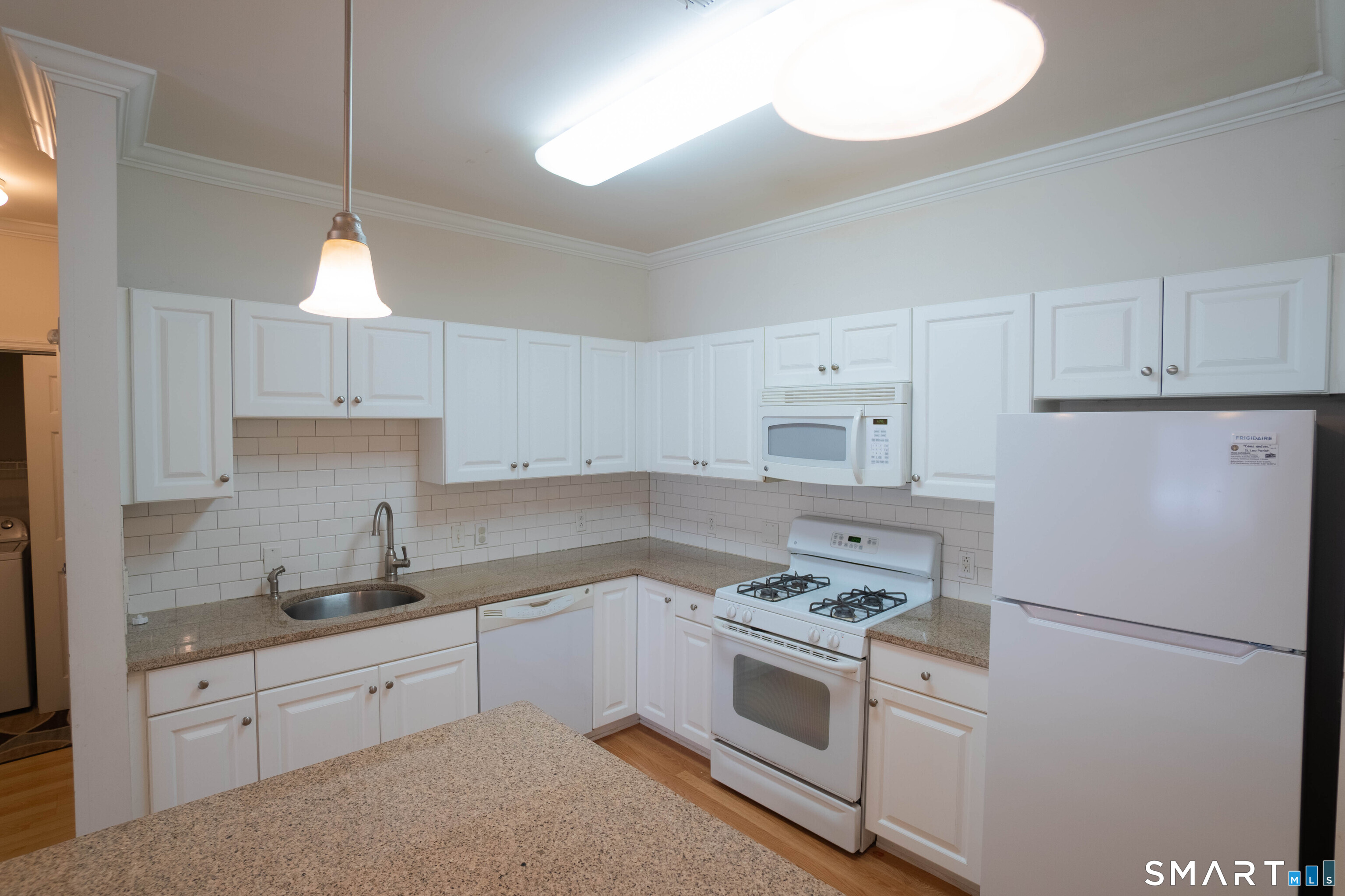 25 Adams Avenue, Unit 112 Stamford, CT 06902 - Photo 5 of 17 a kitchen with cabinets appliances a sink and a counter top space
