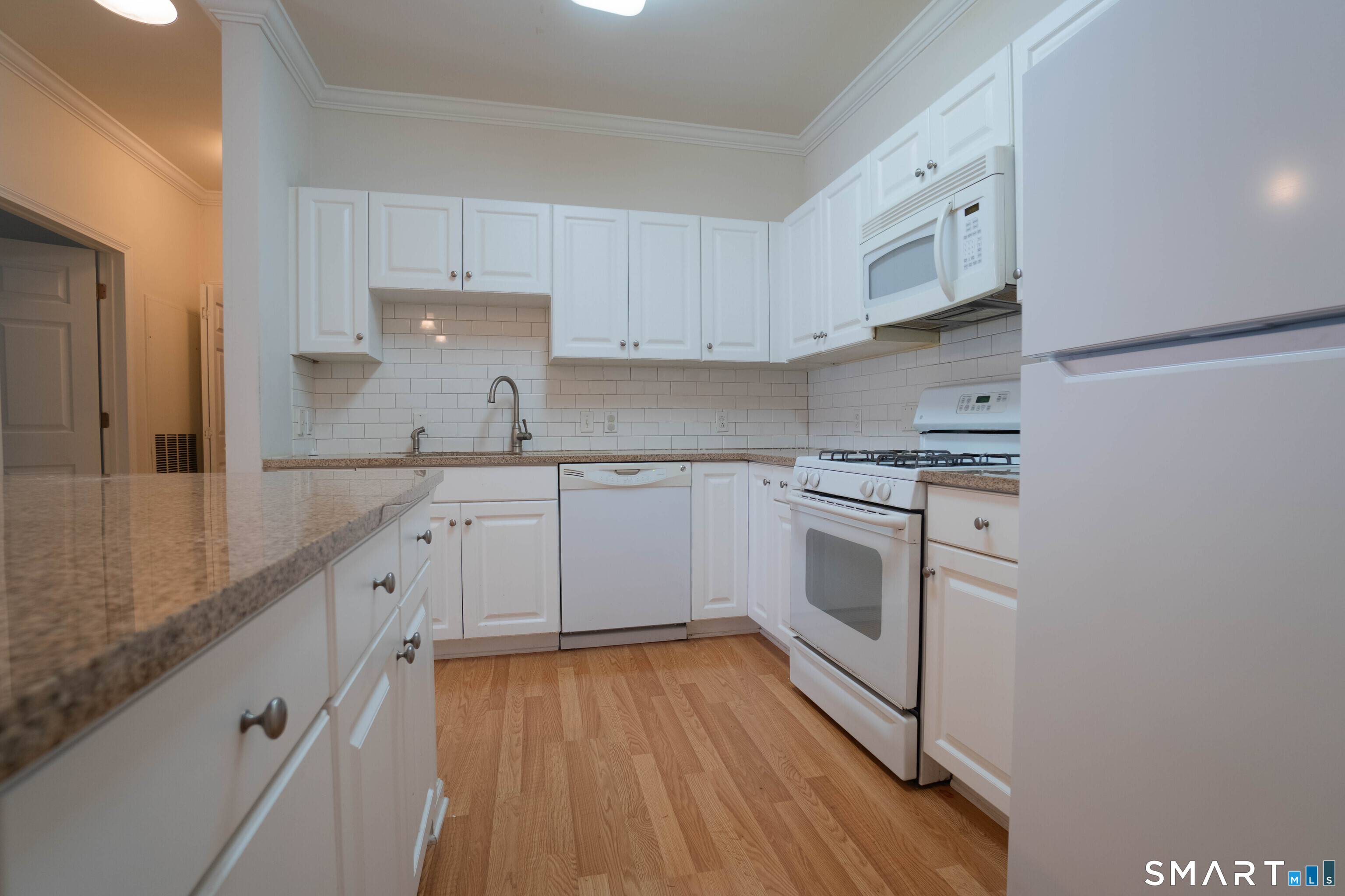 25 Adams Avenue, Unit 112 Stamford, CT 06902 - Photo 6 of 17 a kitchen with granite countertop white cabinets and white appliances