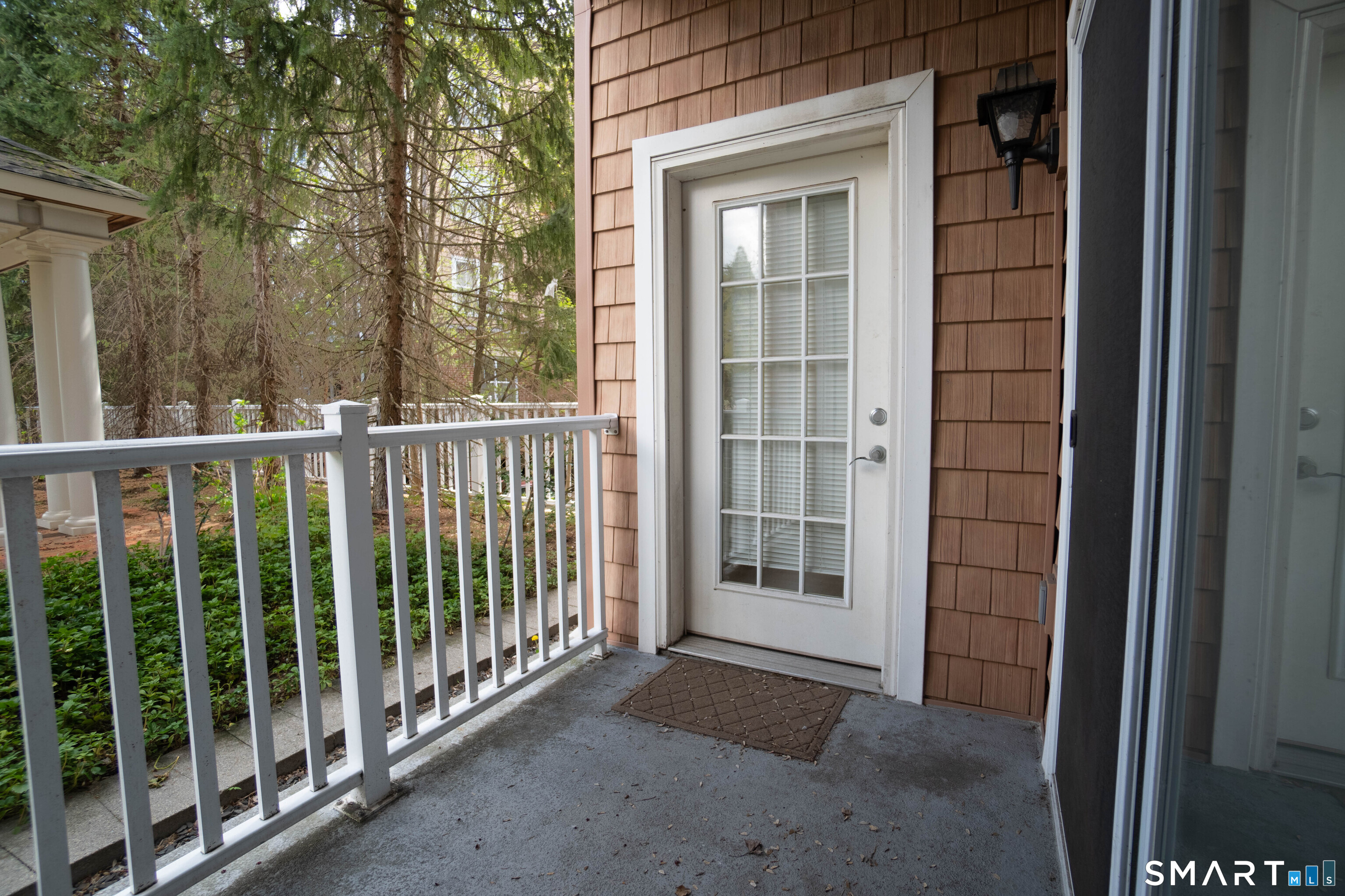 25 Adams Avenue, Unit 112 Stamford, CT 06902 - Photo 10 of 17 a view of a balcony with a floor to ceiling window and wooden fence