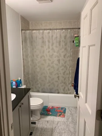 a bathroom with a toilet and a shower curtain