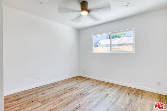 an empty room with a window and wooden floor