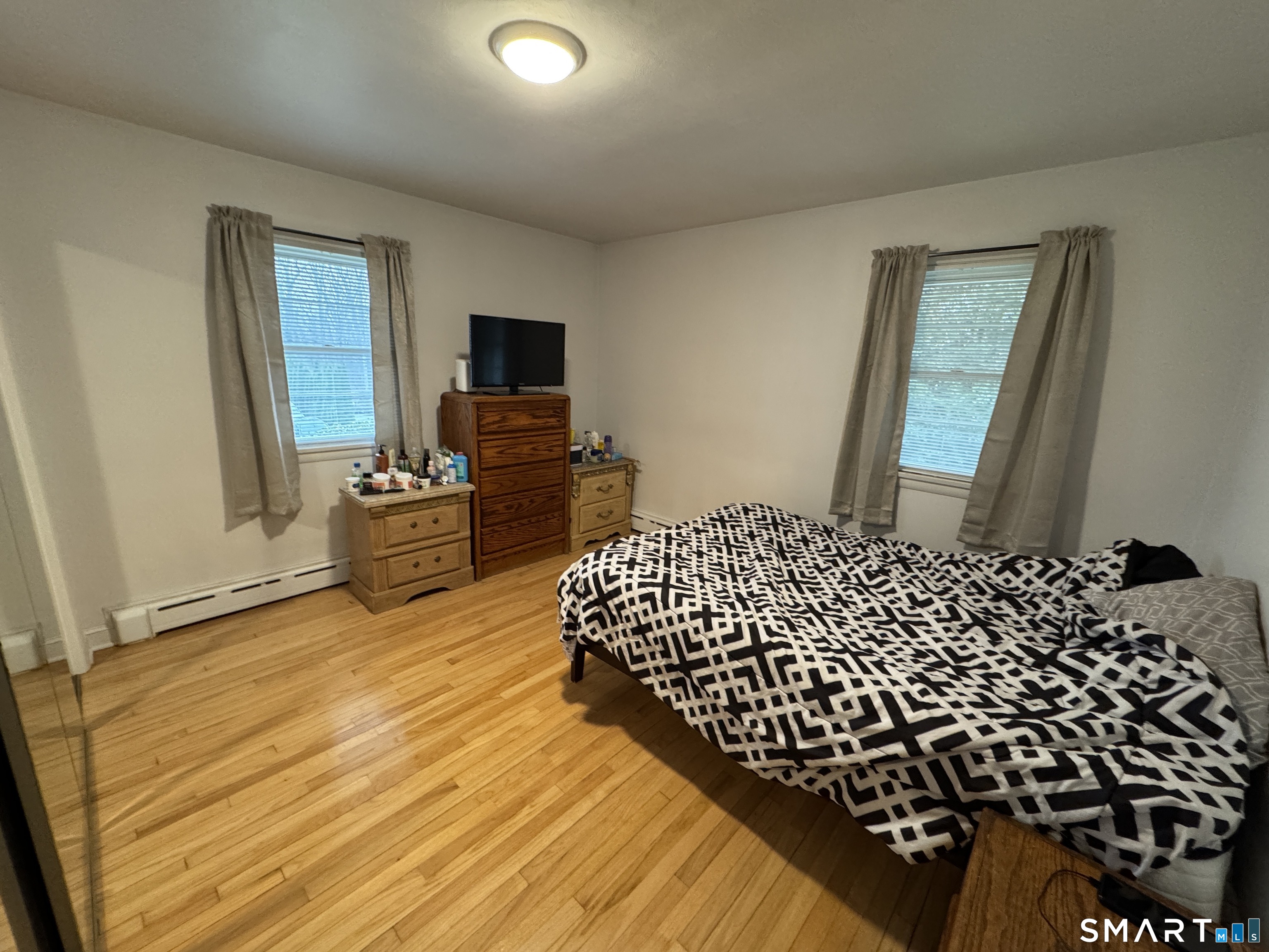 90 Larchmont Avenue Waterbury, CT 06708 - Photo 12 of 26 a bedroom with a bed and wooden floor
