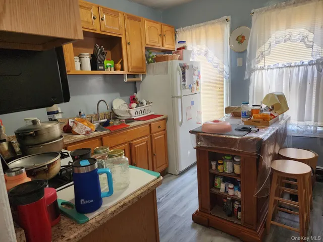 a kitchen with stainless steel appliances kitchen island granite countertop a refrigerator stove and sink