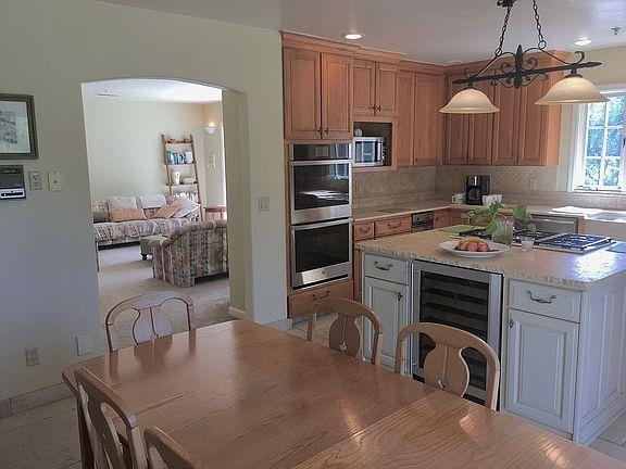 11394 Saddle Road Monterey, CA 93940 - Photo 3 of 33 a kitchen with a table chairs a stove and a refrigerator