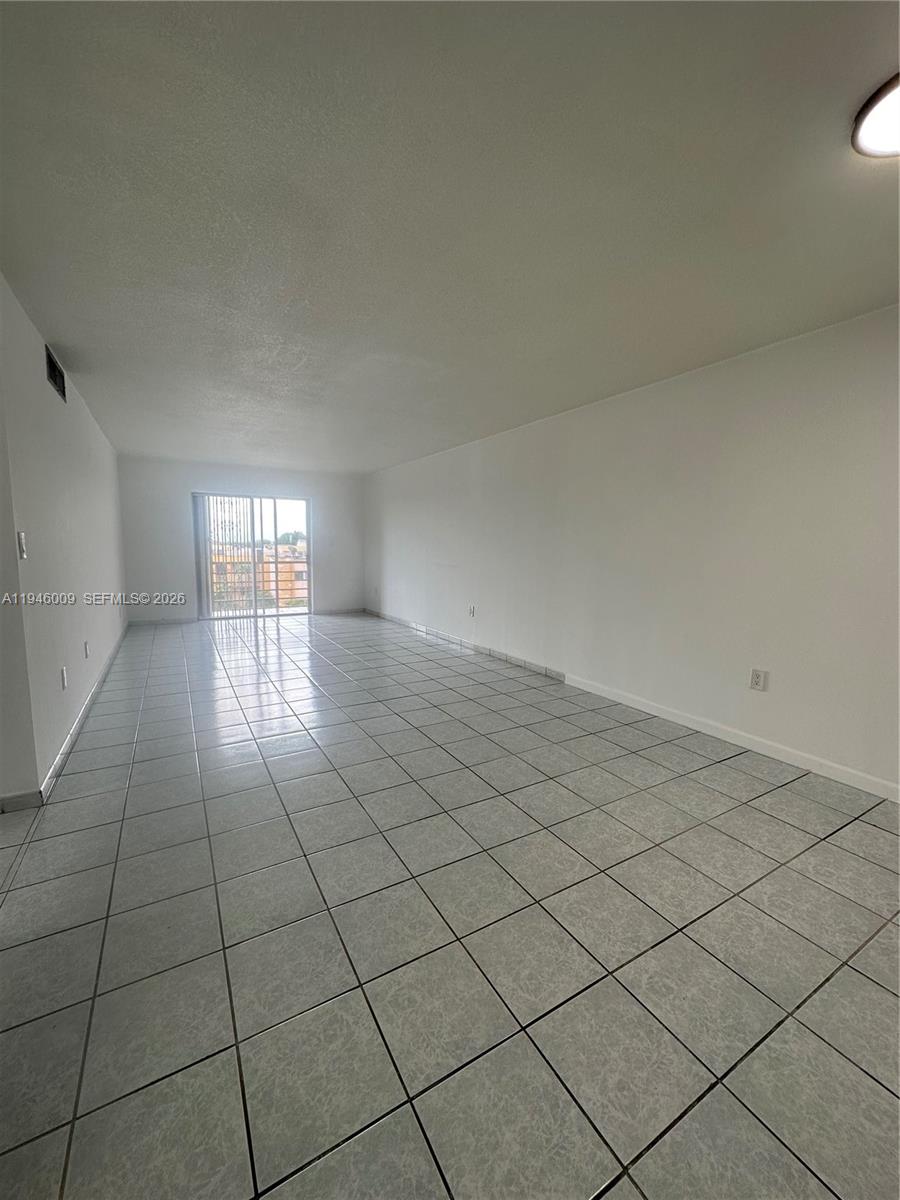 4670 West 13th Lane, Unit 405 Hialeah, FL 33012 - Photo 12 of 16 a view of an empty room and window