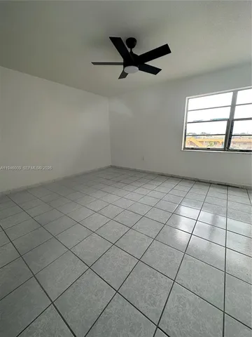 an empty room with windows and ceiling fan