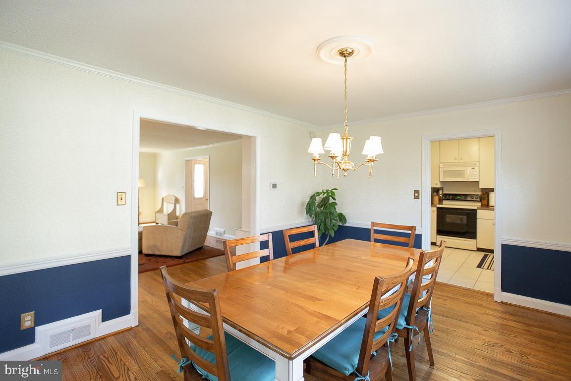 304 Cedarcroft Road Baltimore, MD 21212 - Photo 11 of 39 a dining room with furniture a chandelier and wooden floor
