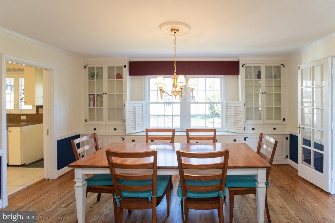 304 Cedarcroft Road Baltimore, MD 21212 - Photo 12 of 39 a dining room with wooden floor a chandelier a wooden table and chairs