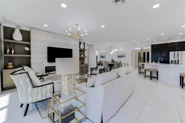 a living room with furniture a flat screen tv and floor to ceiling window