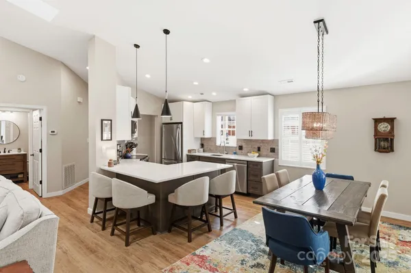 a kitchen with a dining table chairs and white cabinets