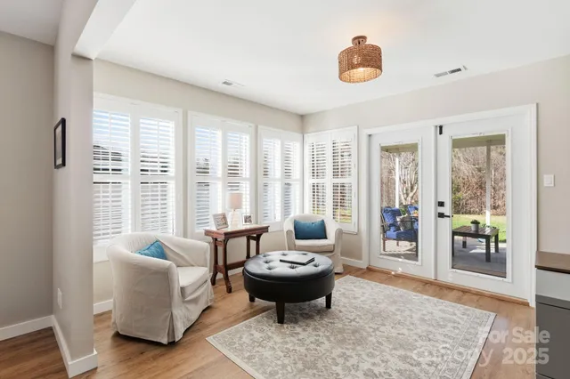 a living room with furniture and floor to ceiling windows