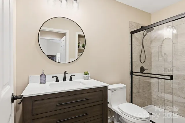 a bathroom with a sink a mirror a vanity and a shower