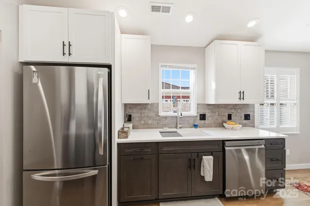 a kitchen with stainless steel appliances a refrigerator a sink a stove a microwave and island