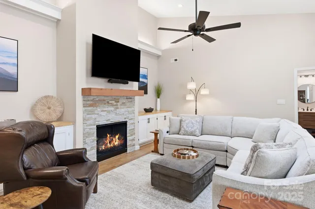 a living room with furniture a flat screen tv and a fireplace