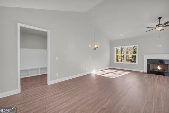 a view of an empty room with a window and fireplace