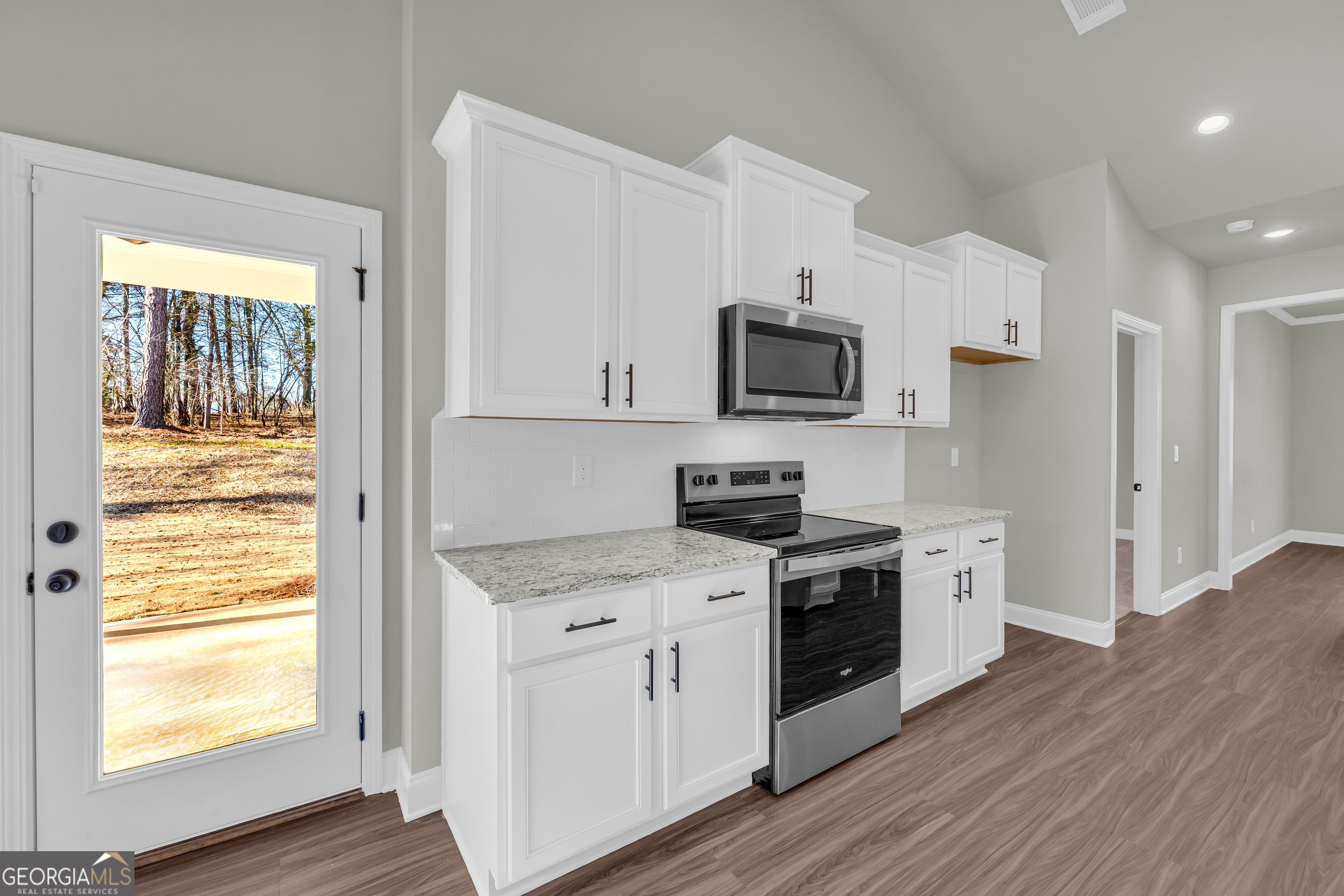 174 Old Milltown Road Hartwell, GA 30643 - Photo 24 of 53 a kitchen with stainless steel appliances granite countertop a stove a sink and white cabinets with wooden floors