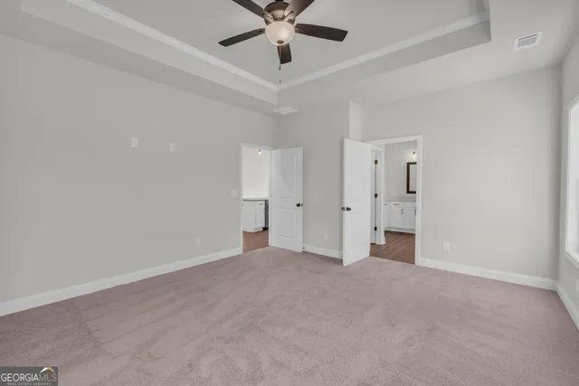 an empty room with windows and a ceiling fan