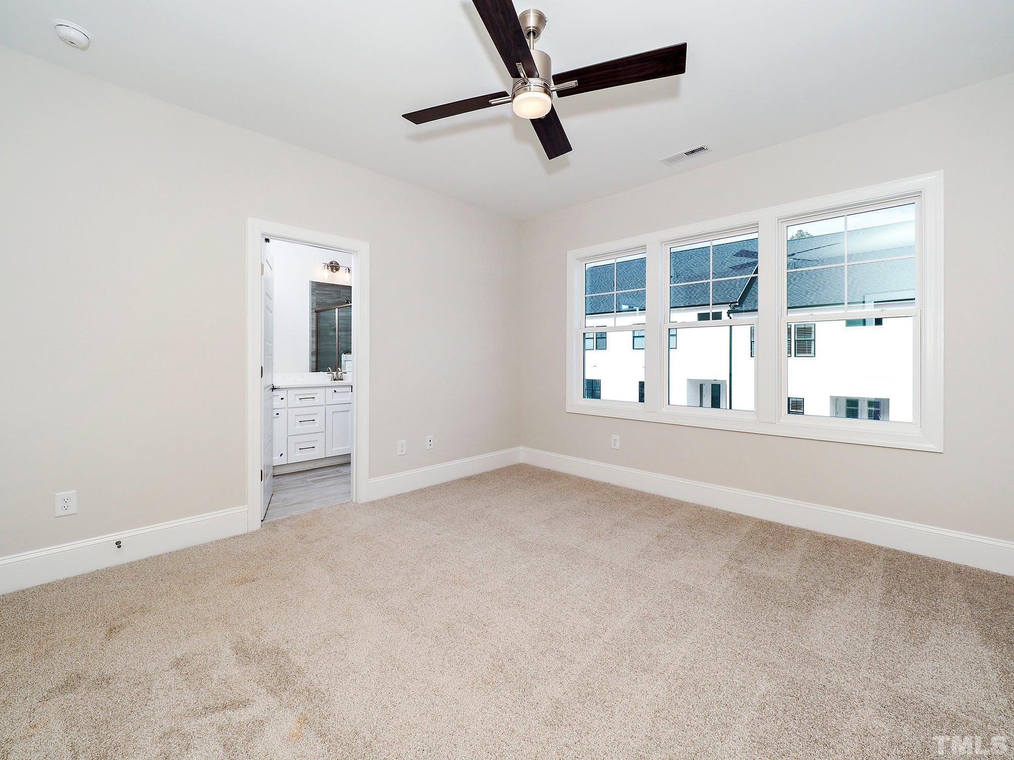 4924 Trek Lane Raleigh, NC 27606 - Photo 21 of 24 an empty room with chandelier fan and windows