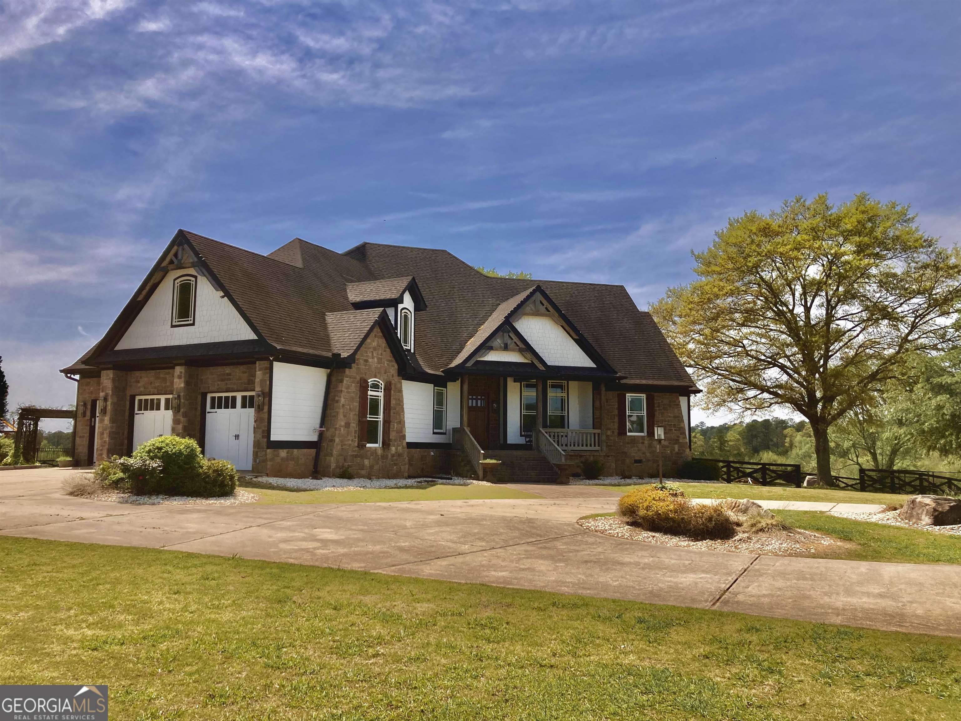 a view of a house with a big yard and large trees