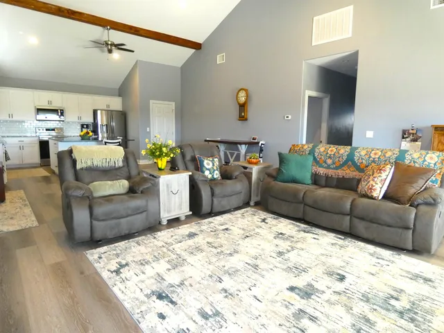 a living room with furniture and view of kitchen