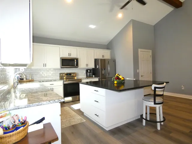 a kitchen with a sink cabinets and wooden floor