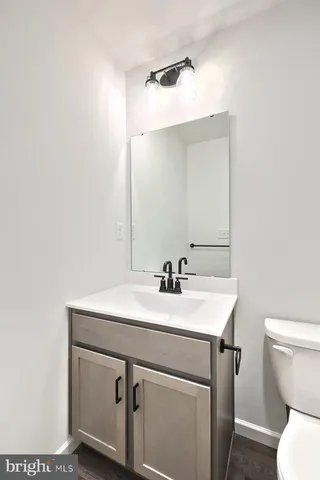a bathroom with a sink toilet vanity and mirror
