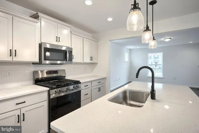 a kitchen with a sink a stove and cabinets