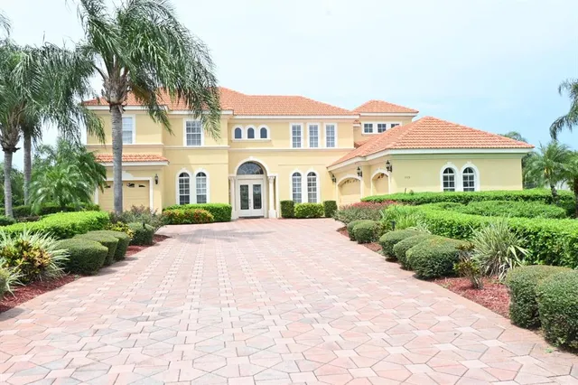 a view of a white house with a yard and potted plants