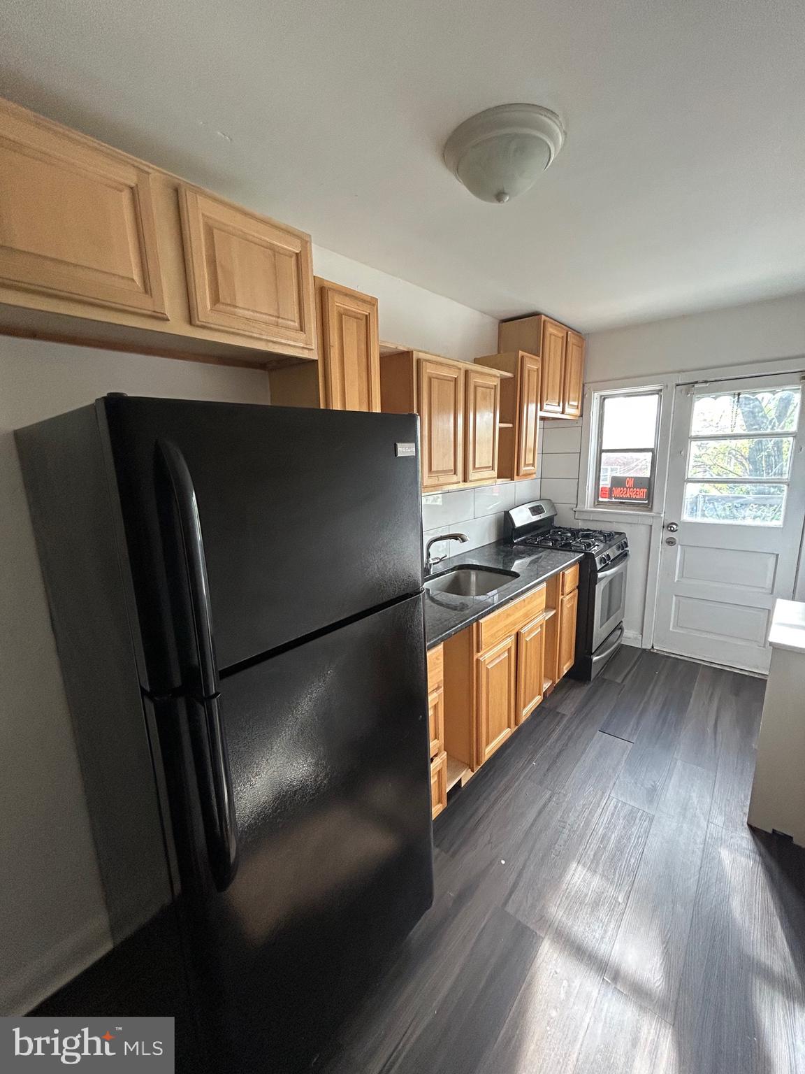 3902 8th Street Brooklyn, MD 21225 - Photo 4 of 11 a kitchen with stainless steel appliances granite countertop a refrigerator a stove a sink and a microwave