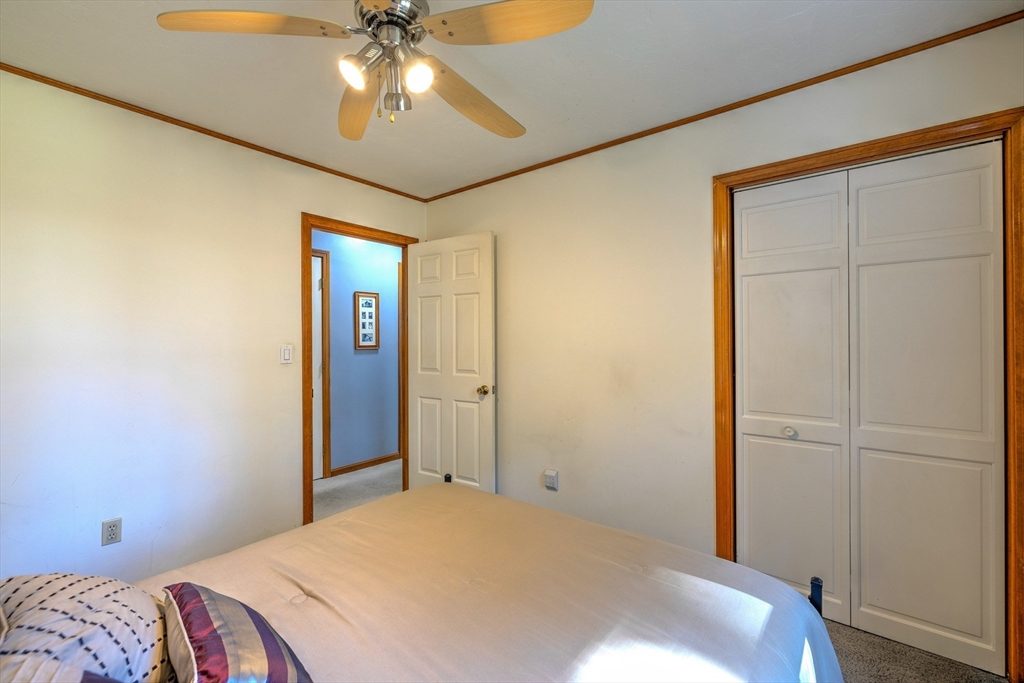 84 Long Hill Road Brookfield, MA 01506 - Photo 12 of 42 a bedroom with a bed and a chandelier