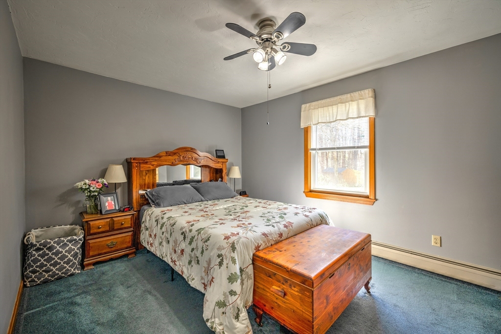 84 Long Hill Road Brookfield, MA 01506 - Photo 13 of 42 a bedroom with a bed and a chandelier