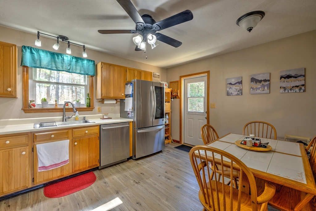 84 Long Hill Road Brookfield, MA 01506 - Photo 3 of 42 a kitchen with stainless steel appliances granite countertop a sink a stove a refrigerator cabinets and dining table