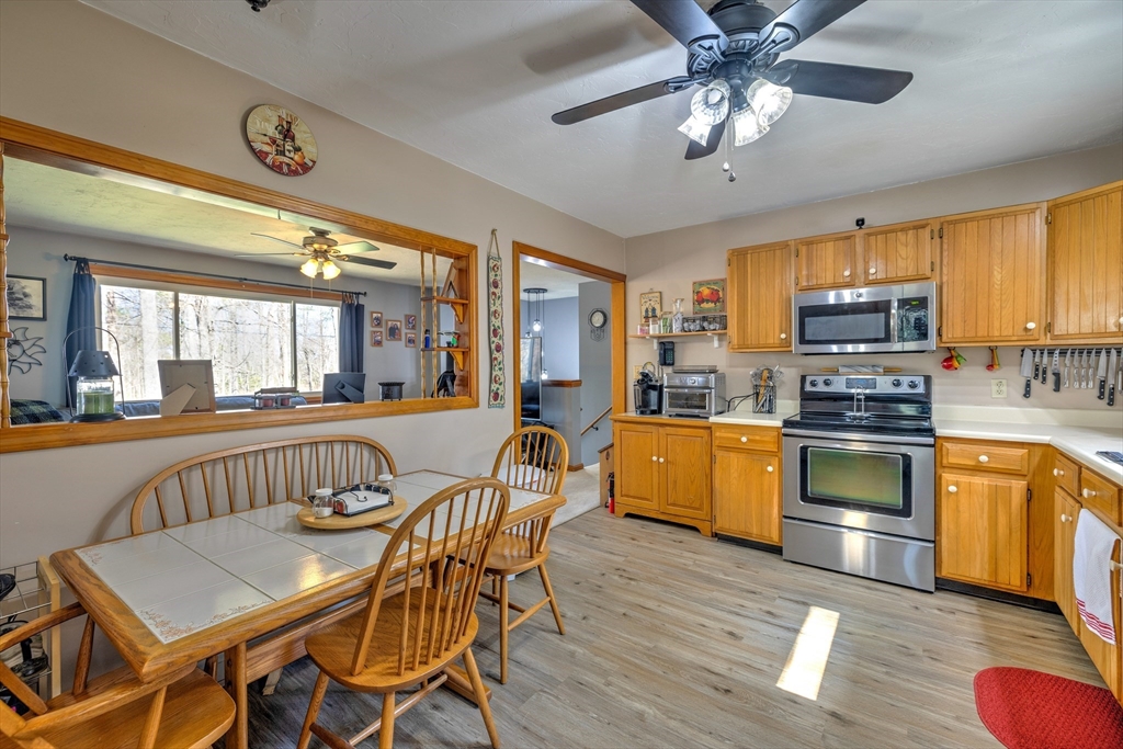 84 Long Hill Road Brookfield, MA 01506 - Photo 5 of 42 a kitchen with stainless steel appliances granite countertop a stove top oven a sink dishwasher a dining table and chairs with wooden floor