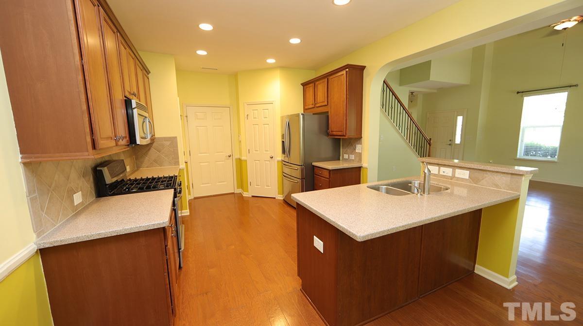 301 Dimock Way Wake Forest, NC 27587 - Photo 5 of 14 Kitchen features stainless appliances, solid surface countertops, walk-in pantry and access to garage.