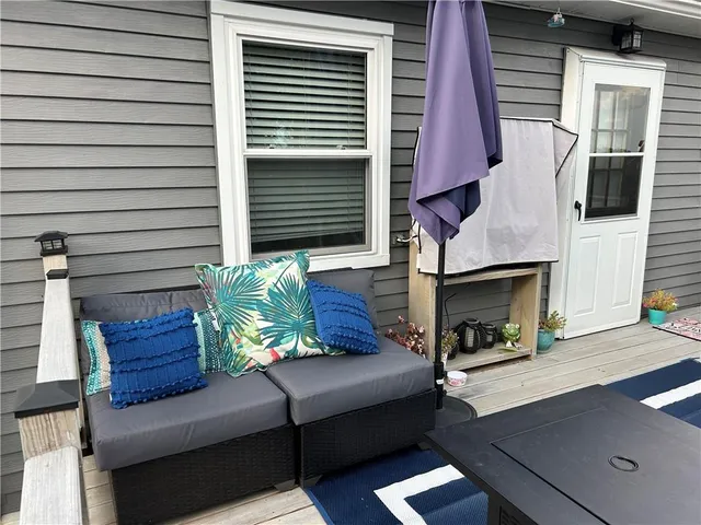 a view of a house with a couches and a fire pit and wooden fence