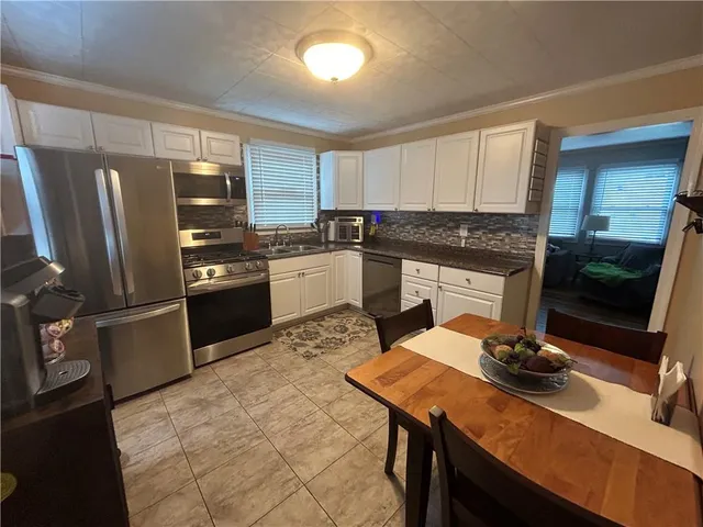 a kitchen with a sink stainless steel appliances and white cabinets