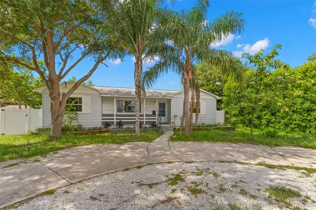 a view of a yard in front of a house with large trees