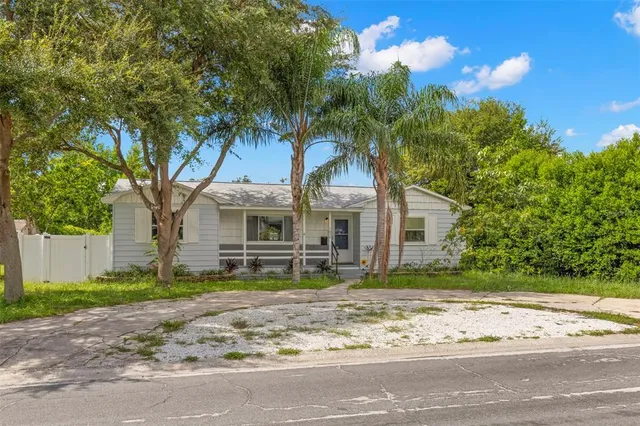 a view of a house with a tree in front of it