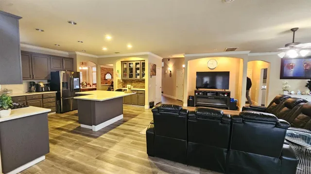 a living room with furniture kitchen view and a large window